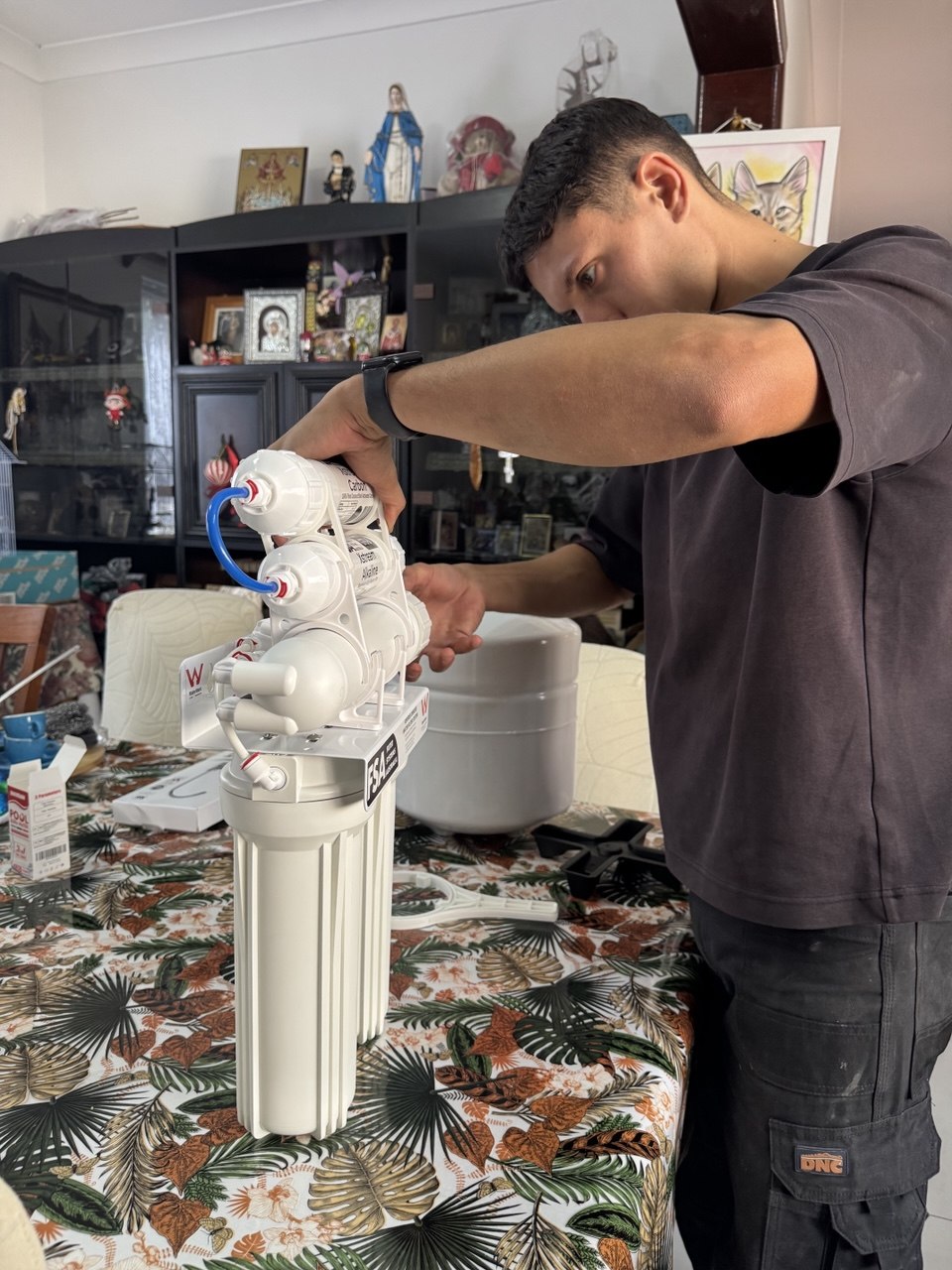 Licensed plumber completing compact water filter installation Sydney