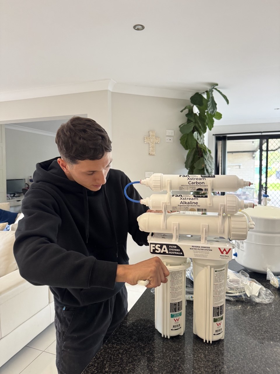 7-stage reverse osmosis system being installed under Sydney kitchen sink