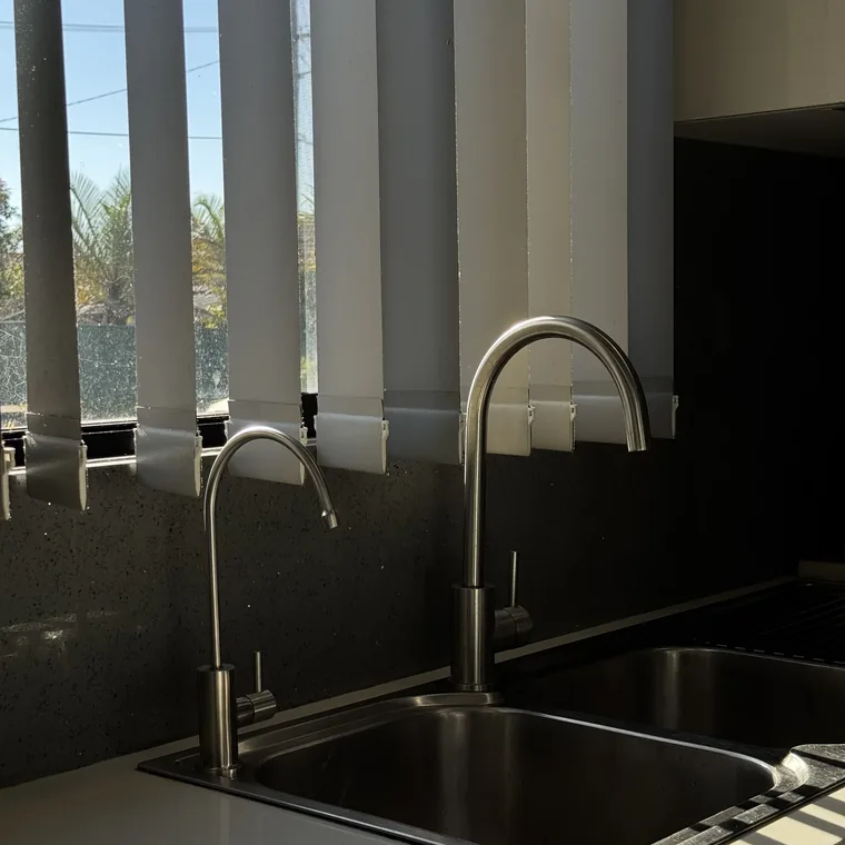 A filter tap in matte black pouring a glass of water